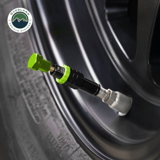 Green tire pressure gauge on a tire with Overland Vehicle Systems logo.