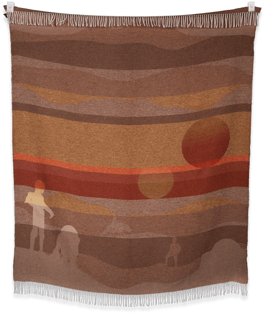 Woven blanket with abstract design of a person, dog, and landscape.