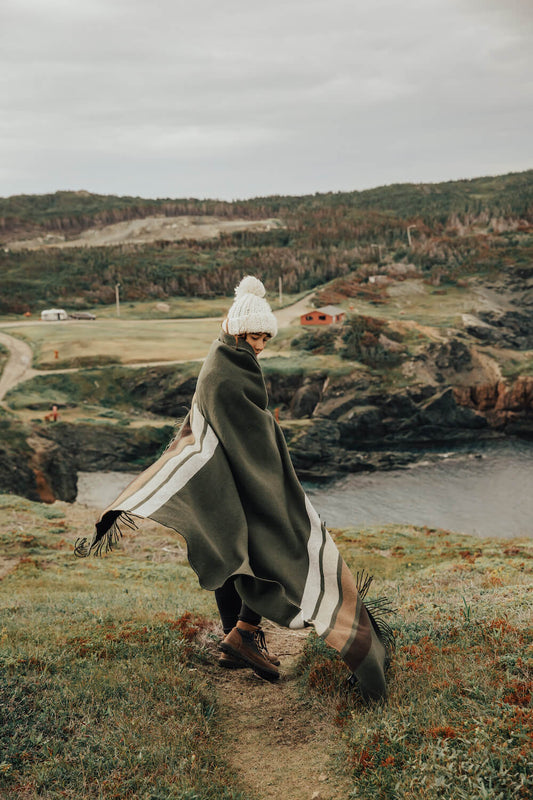 Person walking on a path by a scenic coastal landscape