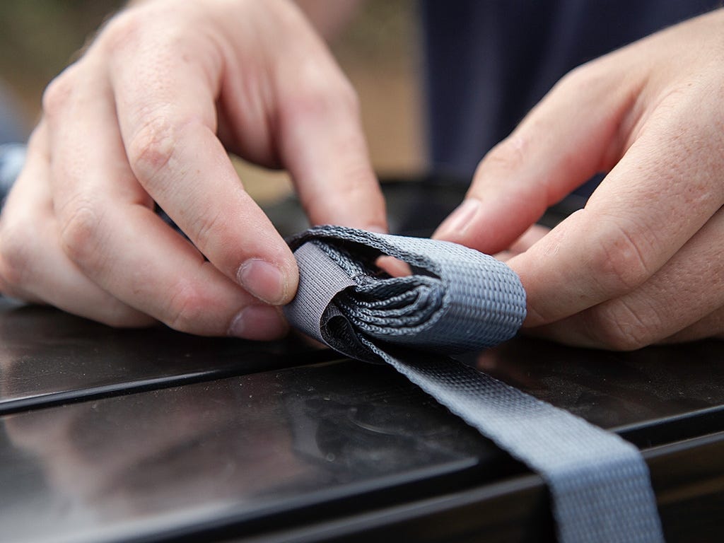 Close-up of hands tying a blue ribbon on a surface