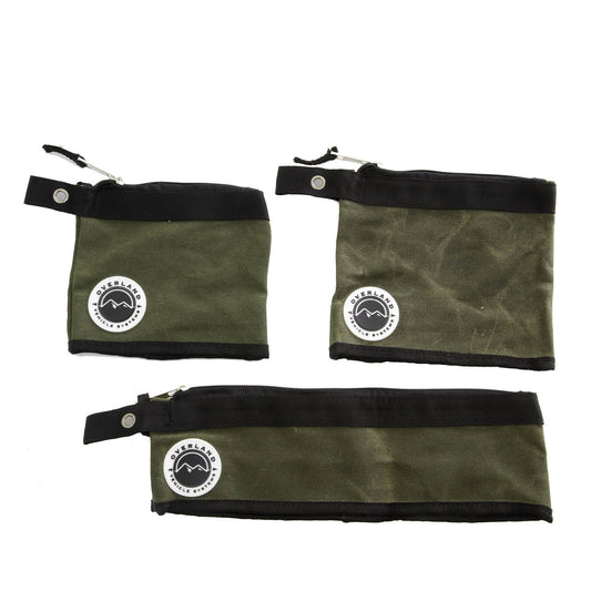 Three green fabric bags with black zippers and logos on a white background