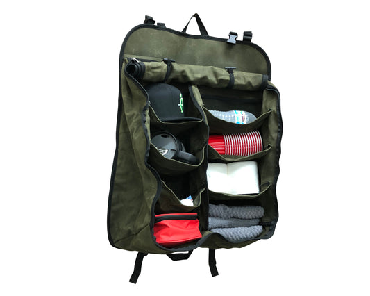 Green travel organizer bag with various items inside on a white background