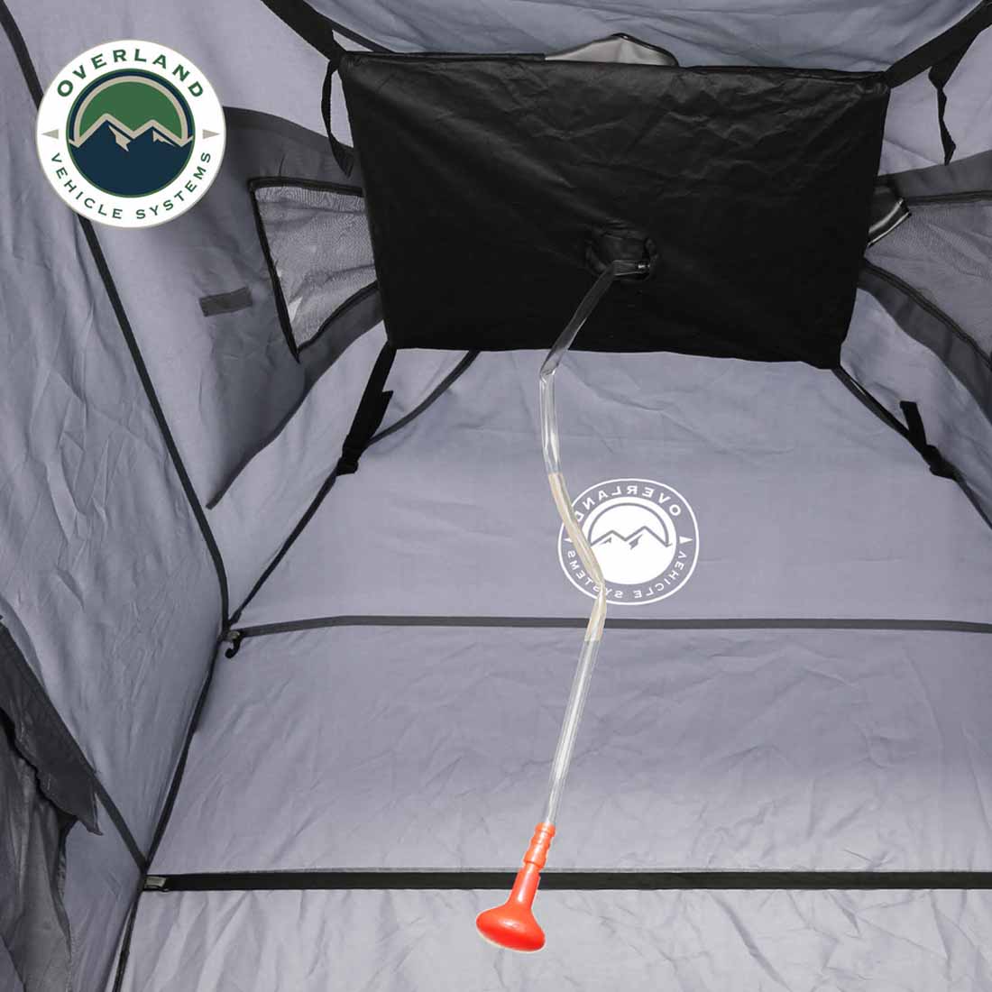 Portable privacy room with pump inside a tent, featuring Overland Vehicle Systems logo.