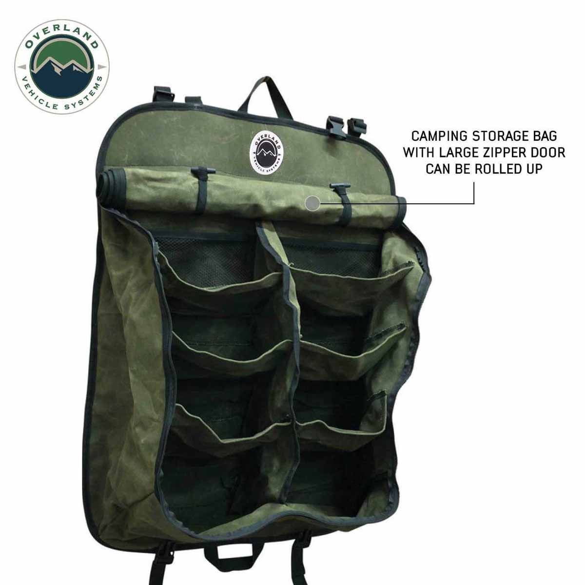 Green camping storage bag with multiple pockets and a large zipper door, featuring Overland Vehicle Systems logo.