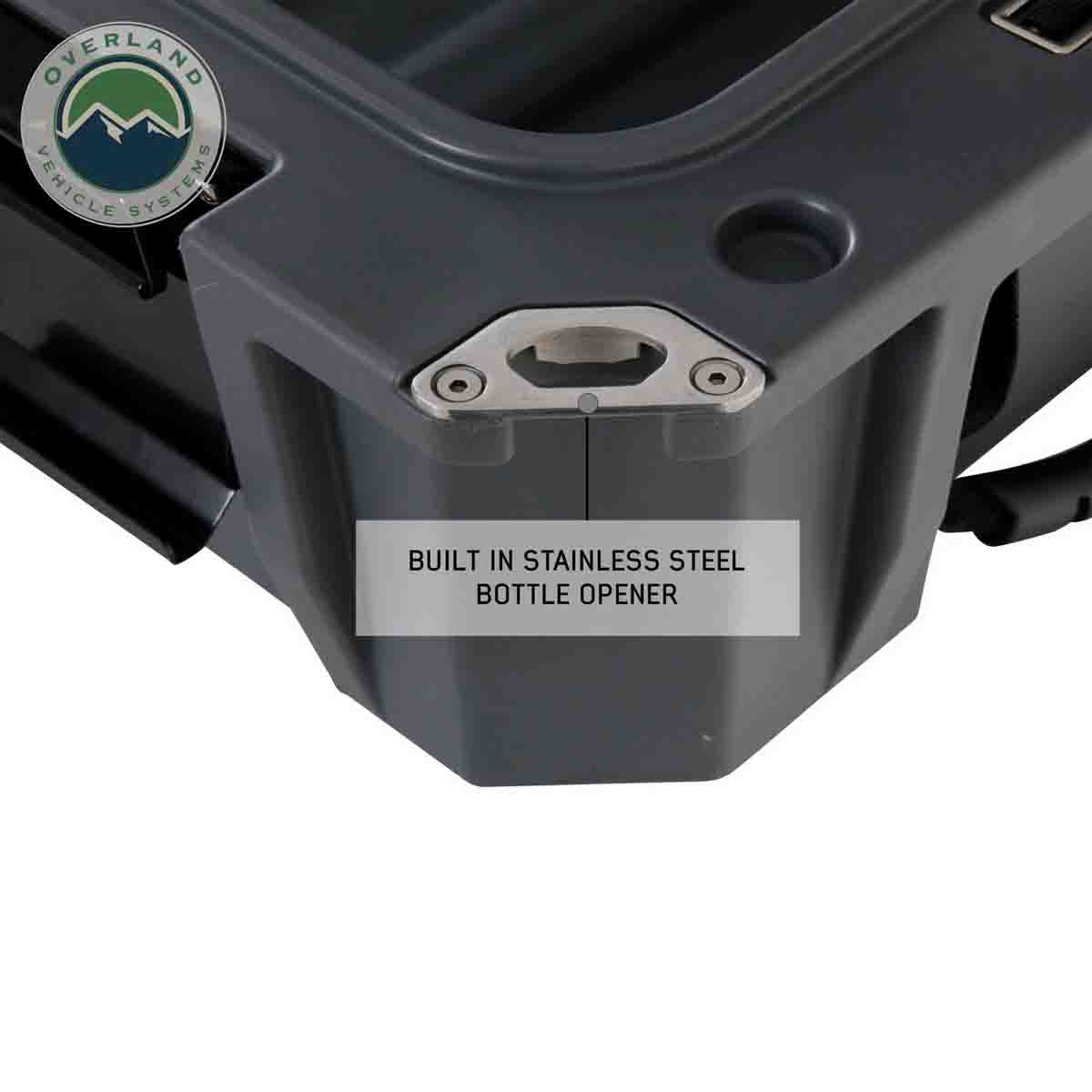 Grtay  storage compartment with stainless steel bottle opener feature and Overland Vehicle Systems logo.