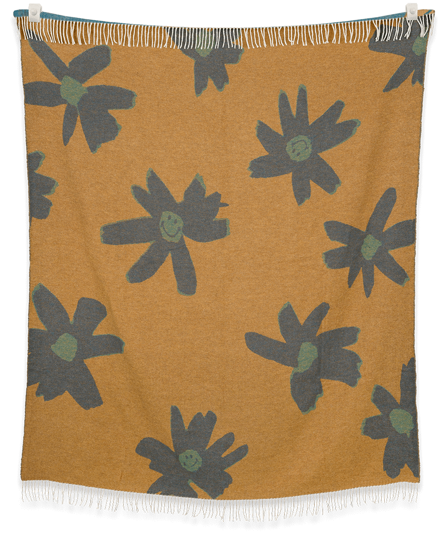 Floral patterned blanket with green flowers on a mustard background
