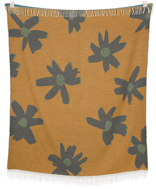 Floral patterned blanket with green flowers on a mustard background