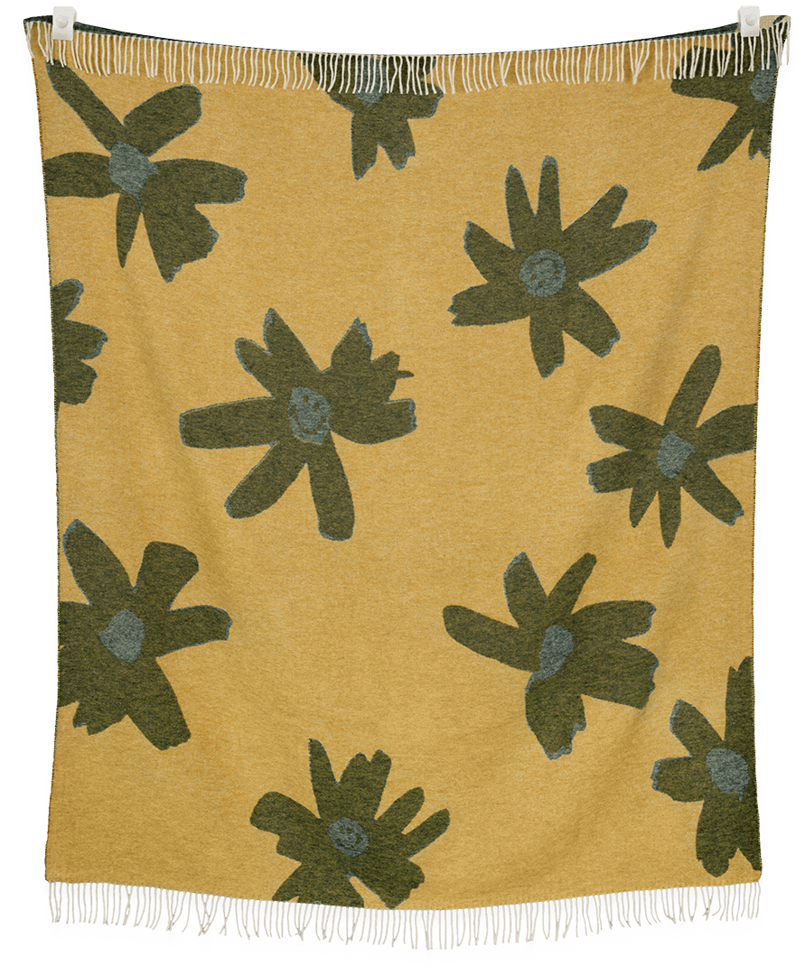 Blanket with green floral patterns on a mustard yellow background