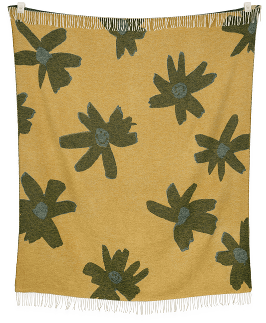 Blanket with green floral patterns on a mustard yellow background