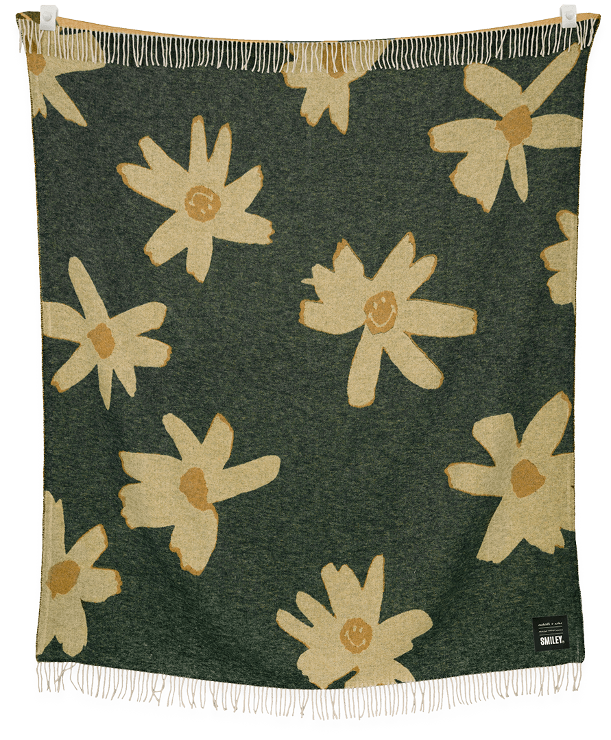 Floral patterned blanket with white flowers on a green background