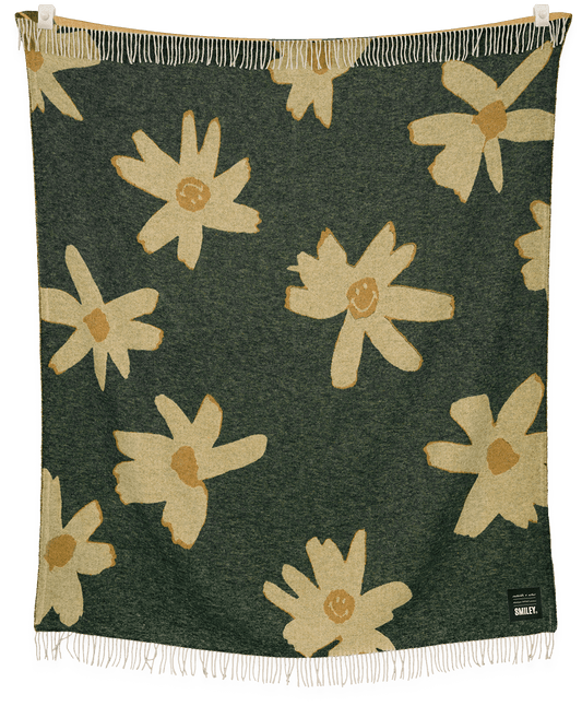 Floral patterned blanket with white flowers on a green background