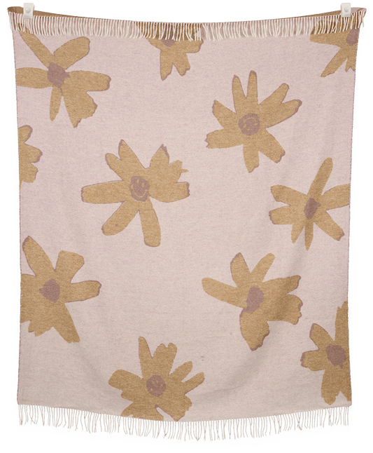 Floral patterned throw blanket with beige flowers on a light pink background