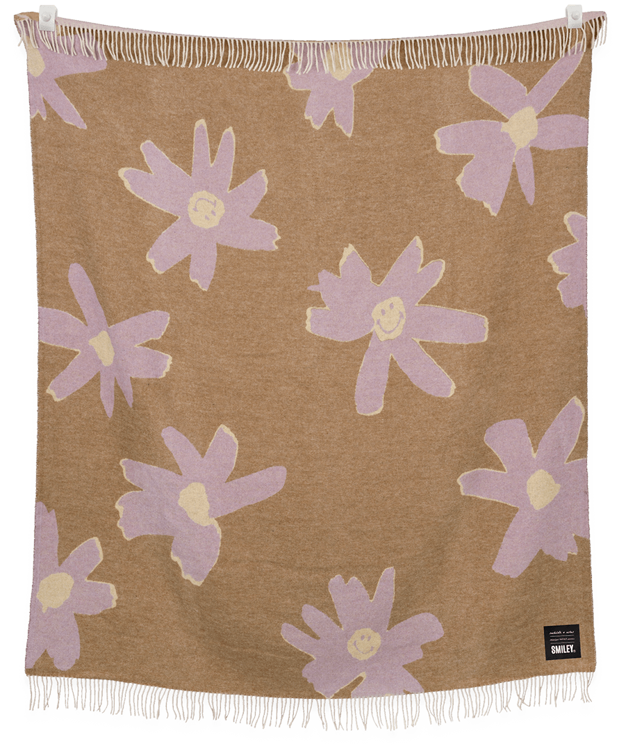 Floral patterned blanket with purple flowers on a brown background, featuring the brand 'Sweetie'.