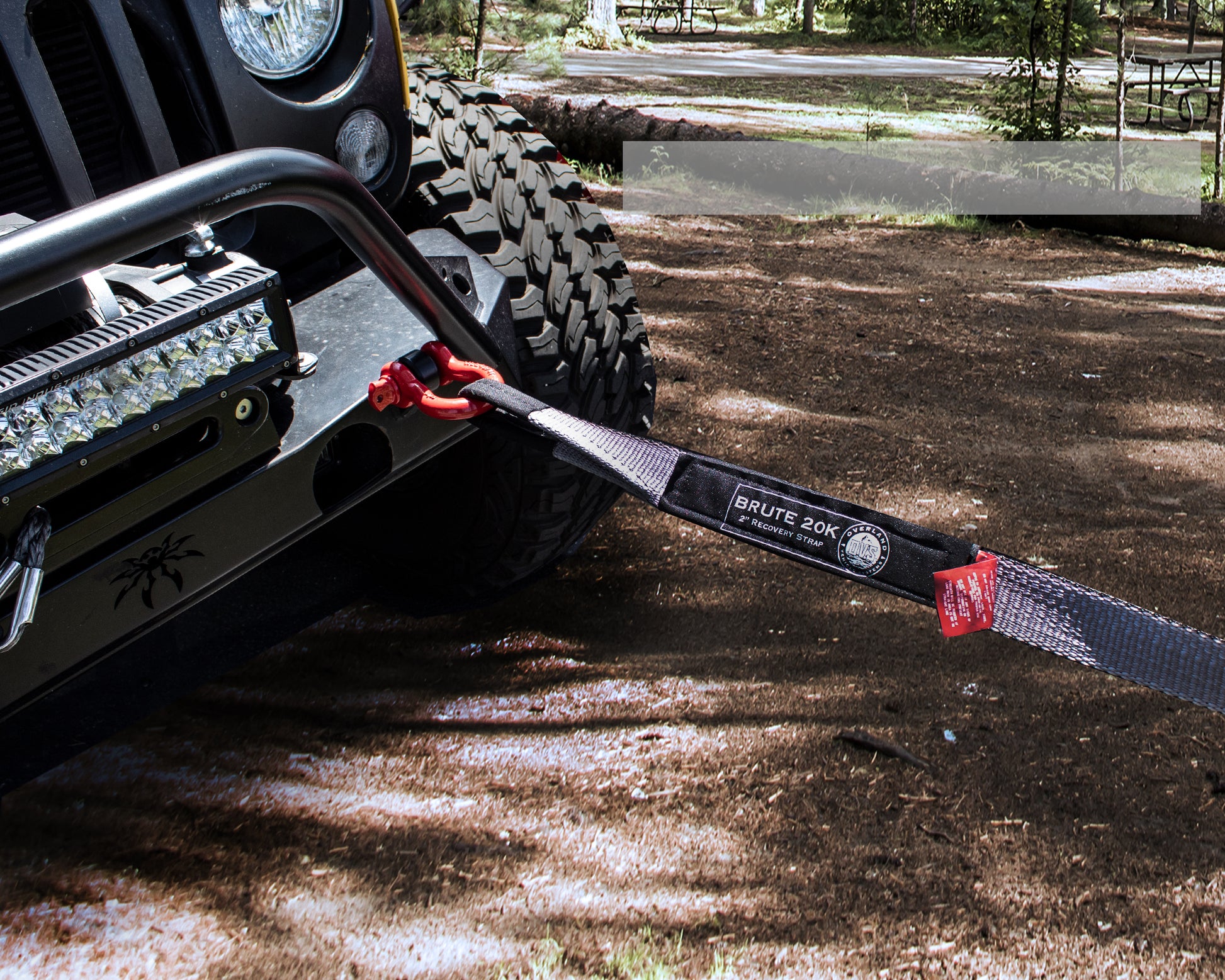 Towed vehicle with a Brute Jack strap on a dirt road