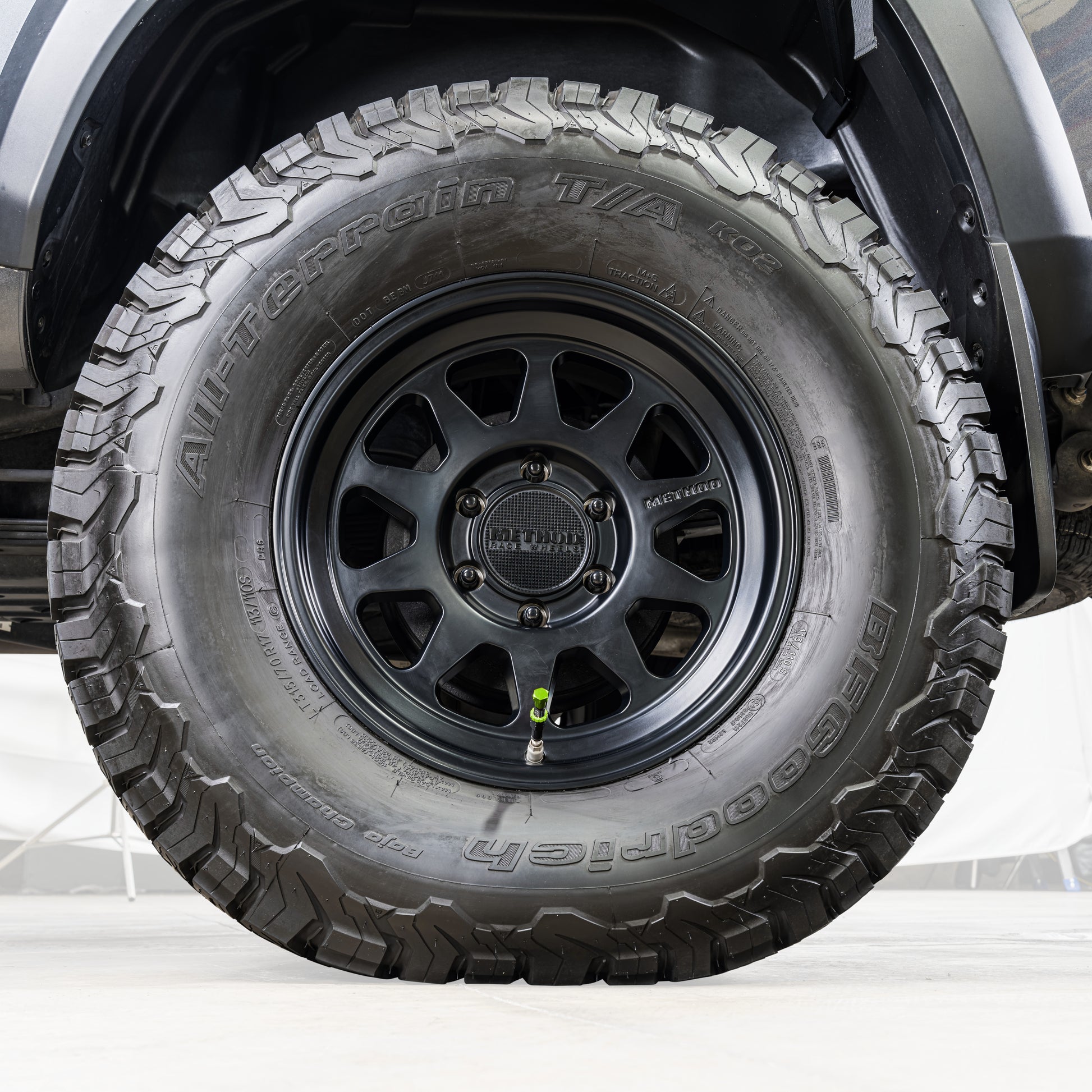 Close-up of a tire with a detailed tread pattern on a vehicle.
