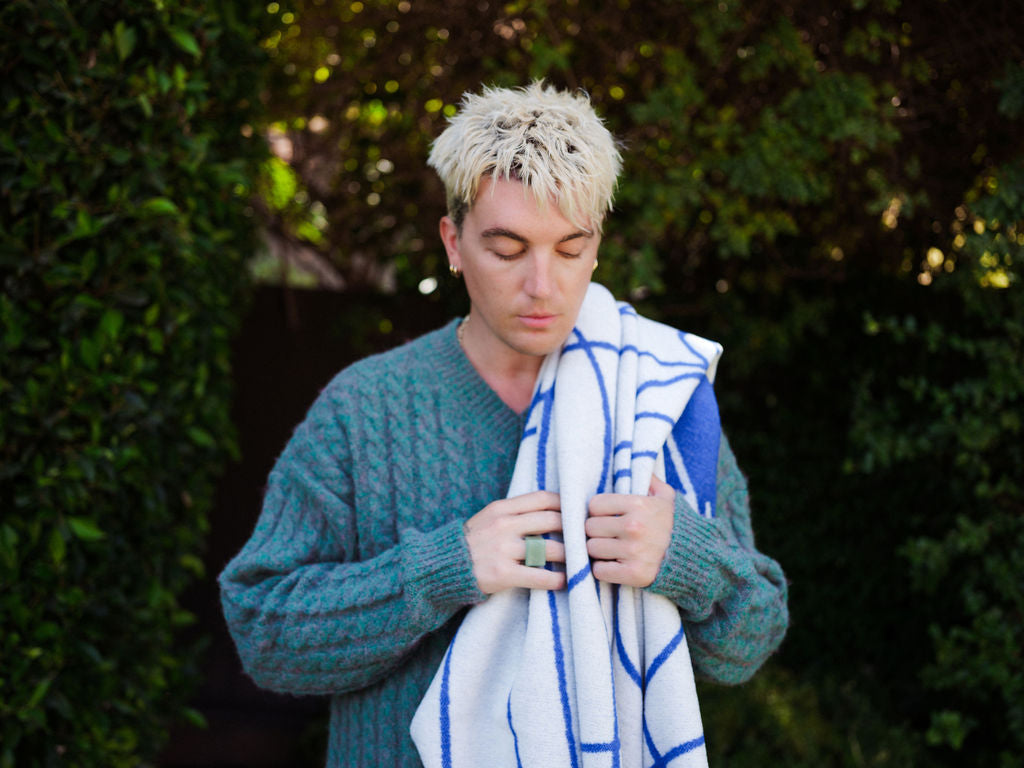 Person holding a blue and white striped towel outdoors