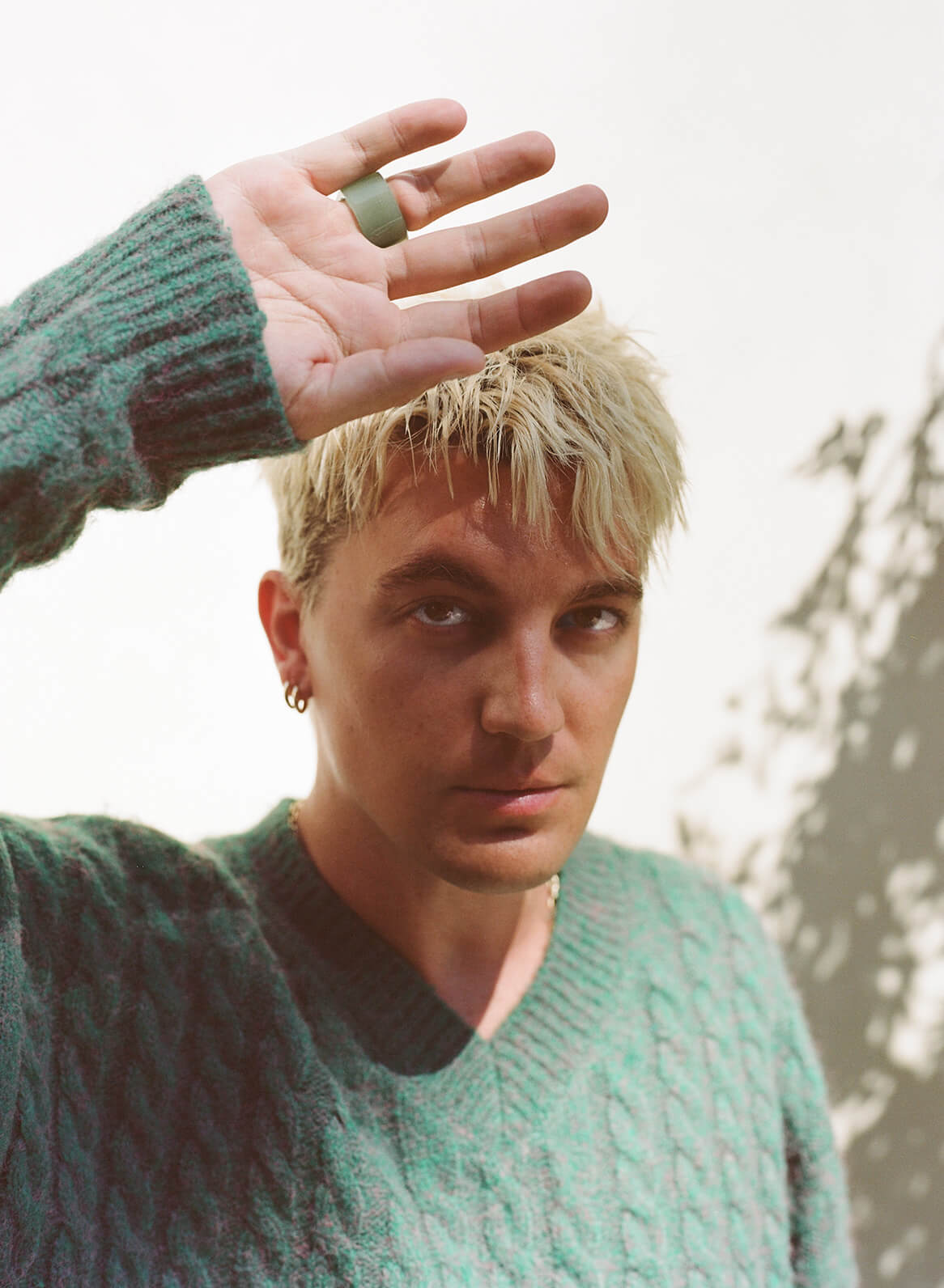 Person wearing a green sweater with a blurred background
