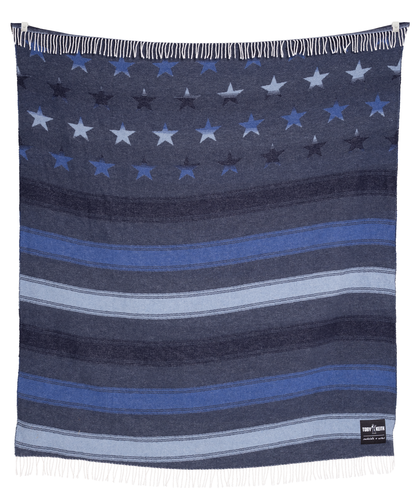 Navy blanket with star and stripe pattern, featuring a brand label on the corner.