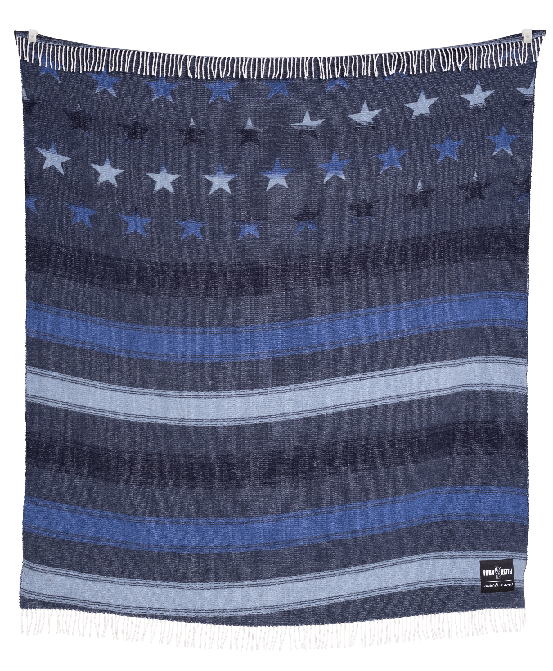 Navy blanket with star and stripe pattern, featuring a brand label on the corner.