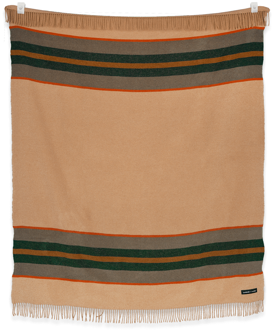 Beige blanket with horizontal stripes in green, brown, and orange on a black background