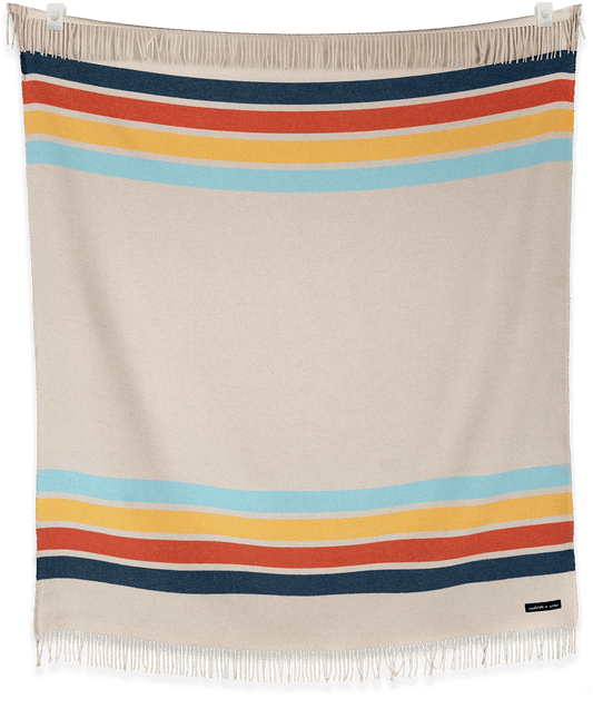 Beige blanket with colorful horizontal stripes on a black background