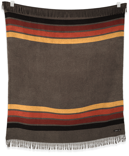 Striped blanket with brown, red, and yellow colors on a black background