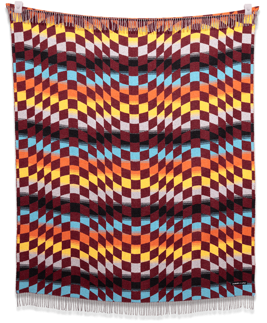Colorful woven blanket with geometric pattern on a black background