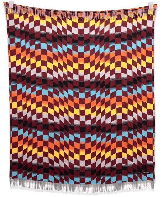 Colorful woven blanket with geometric pattern on a black background