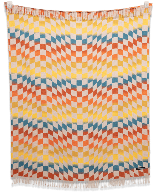 Colorful woven blanket with geometric pattern on a black background