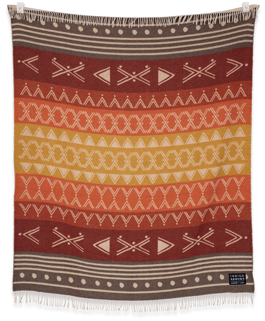 Woven blanket with geometric pattern in red, orange, and brown on a black background