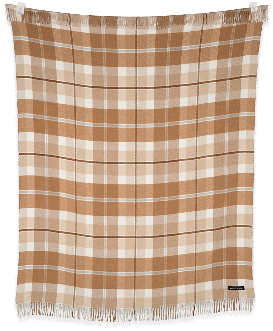 Plaid blanket with brown and white pattern on a black background