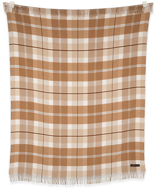 Plaid blanket with brown and white pattern on a black background