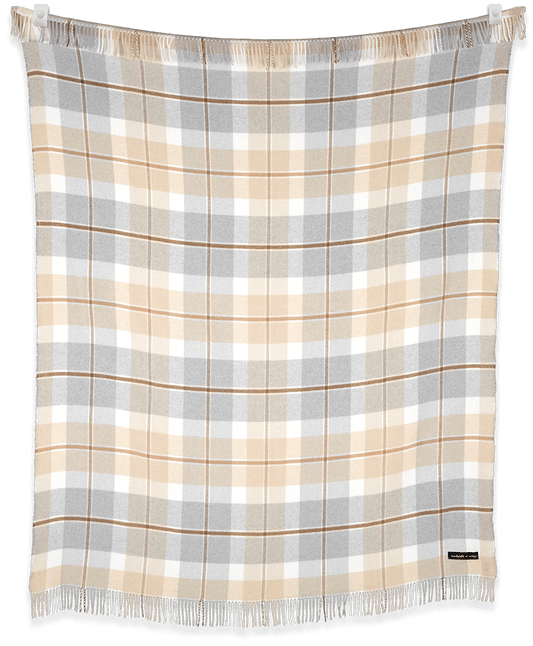 Plaid blanket with beige, gray, and white pattern on a black background