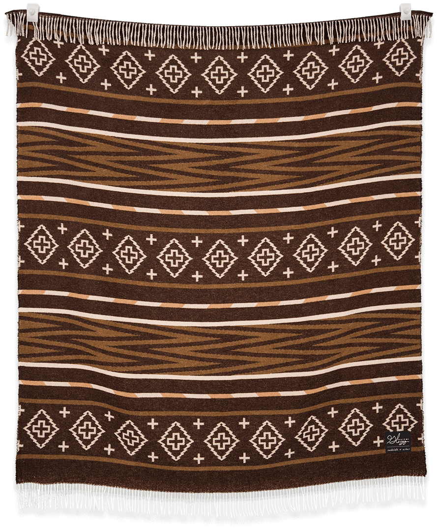Brown patterned blanket with white geometric designs on a black background