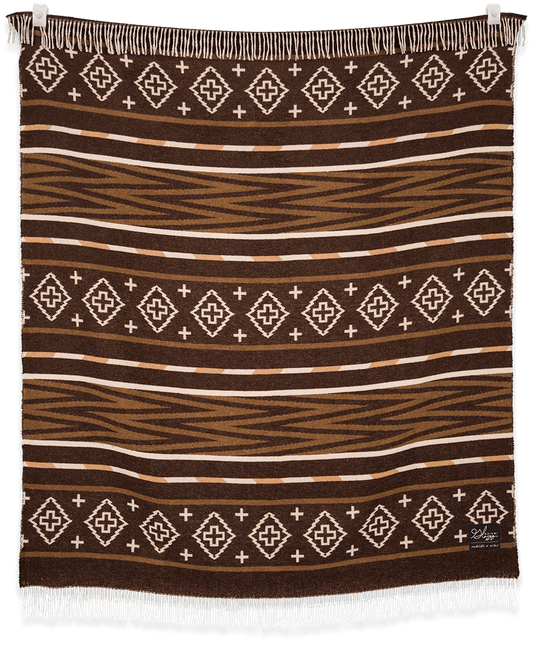 Brown patterned blanket with white geometric designs on a black background