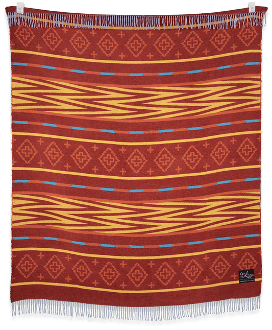 Woven blanket with red, orange, and blue pattern on a black background