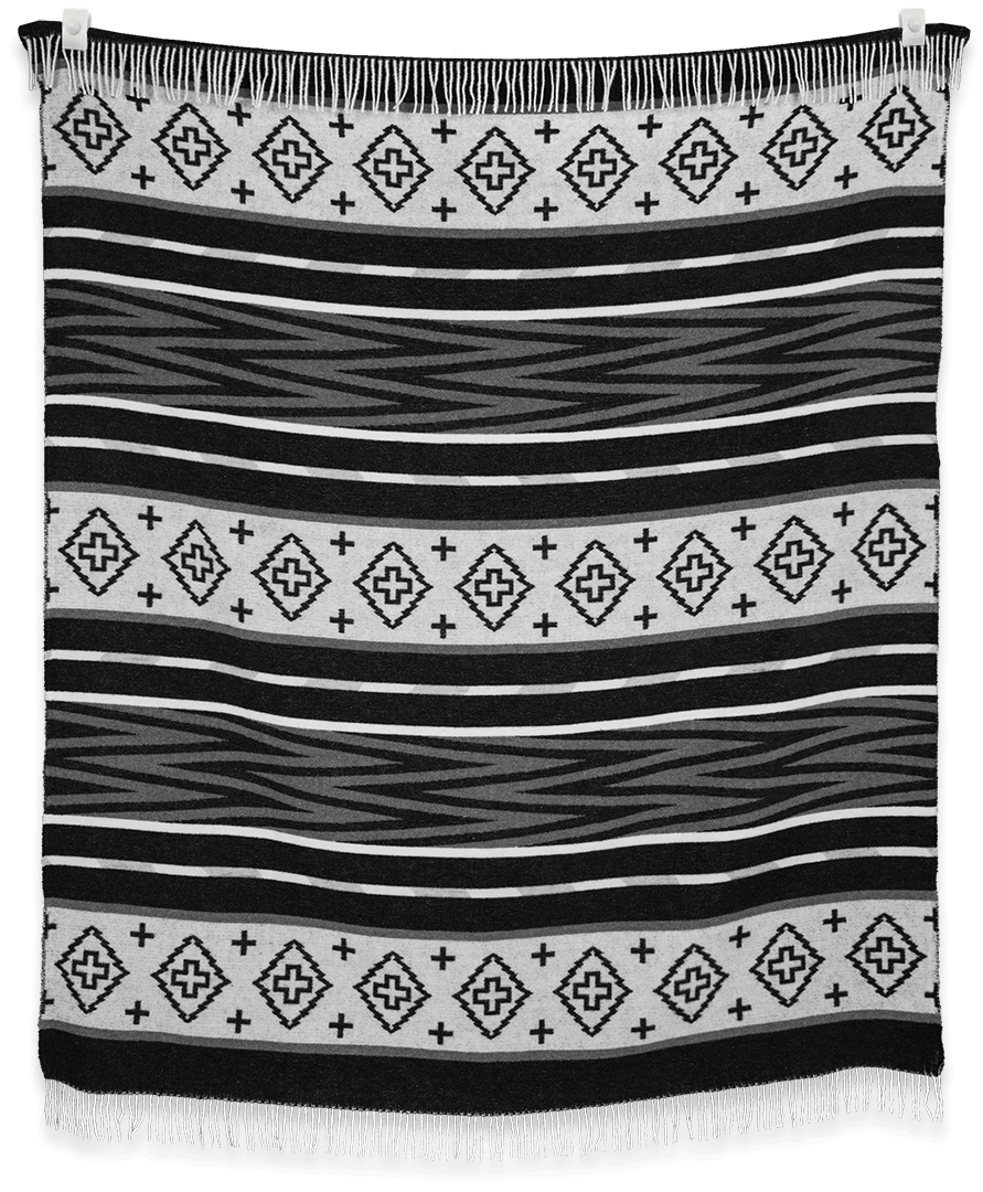 Black and white patterned blanket with fringes on a plain background