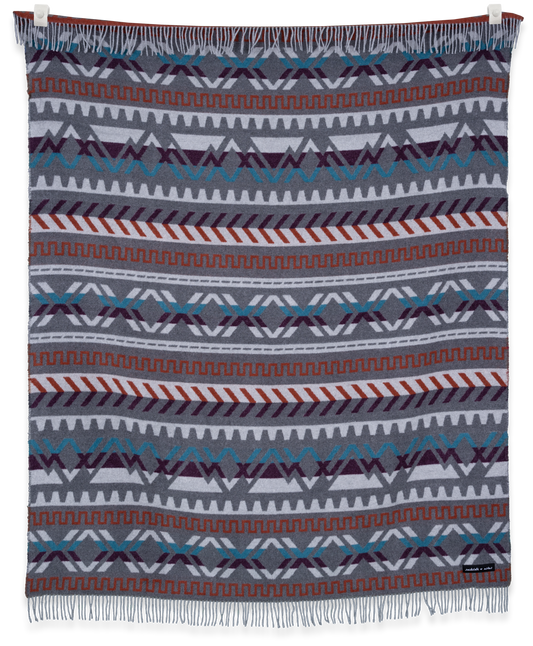 Woven blanket with geometric pattern on a white background