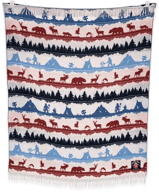 Woven blanket with nature-themed pattern featuring animals and landscapes.