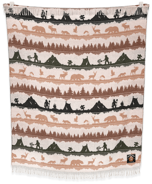 Woven blanket with nature-themed design featuring trees, animals, and people on a black background.