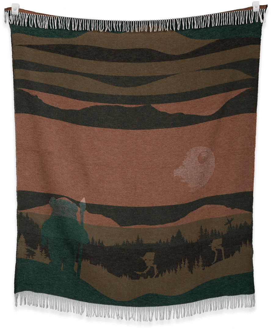 Woven blanket with a landscape design featuring a bear and trees, hanging on a black background.