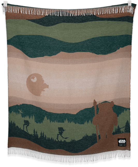 Woven blanket with a landscape design featuring a bear, trees, and a moon.