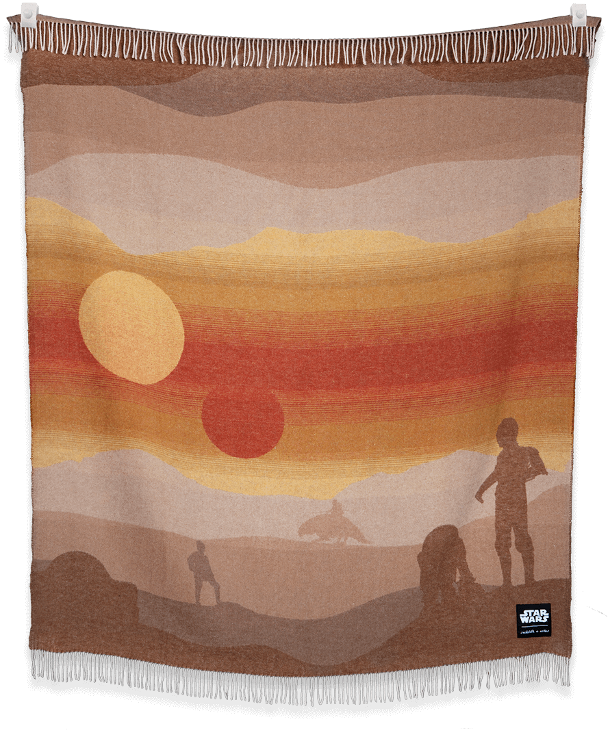 Woven blanket with desert landscape design featuring people, animals, and a sunset.