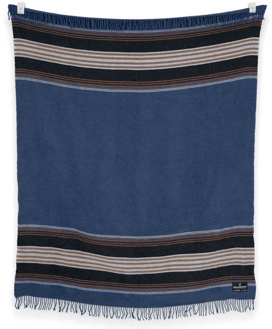 Blue towel with striped patterns hanging against a black background