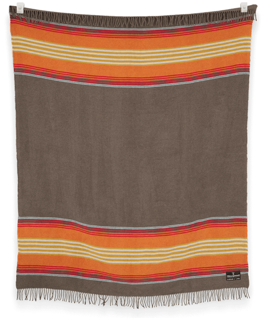 Striped blanket with orange, red, and beige stripes on a brown background