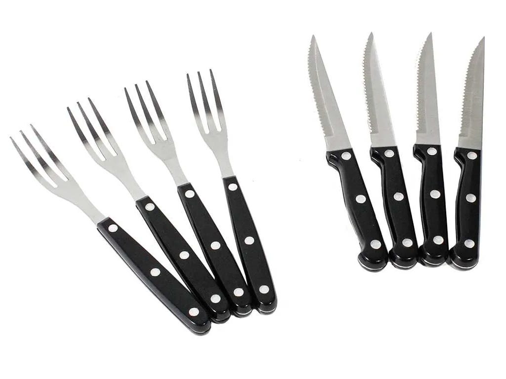 Set of black-handled knives and forks on a white background