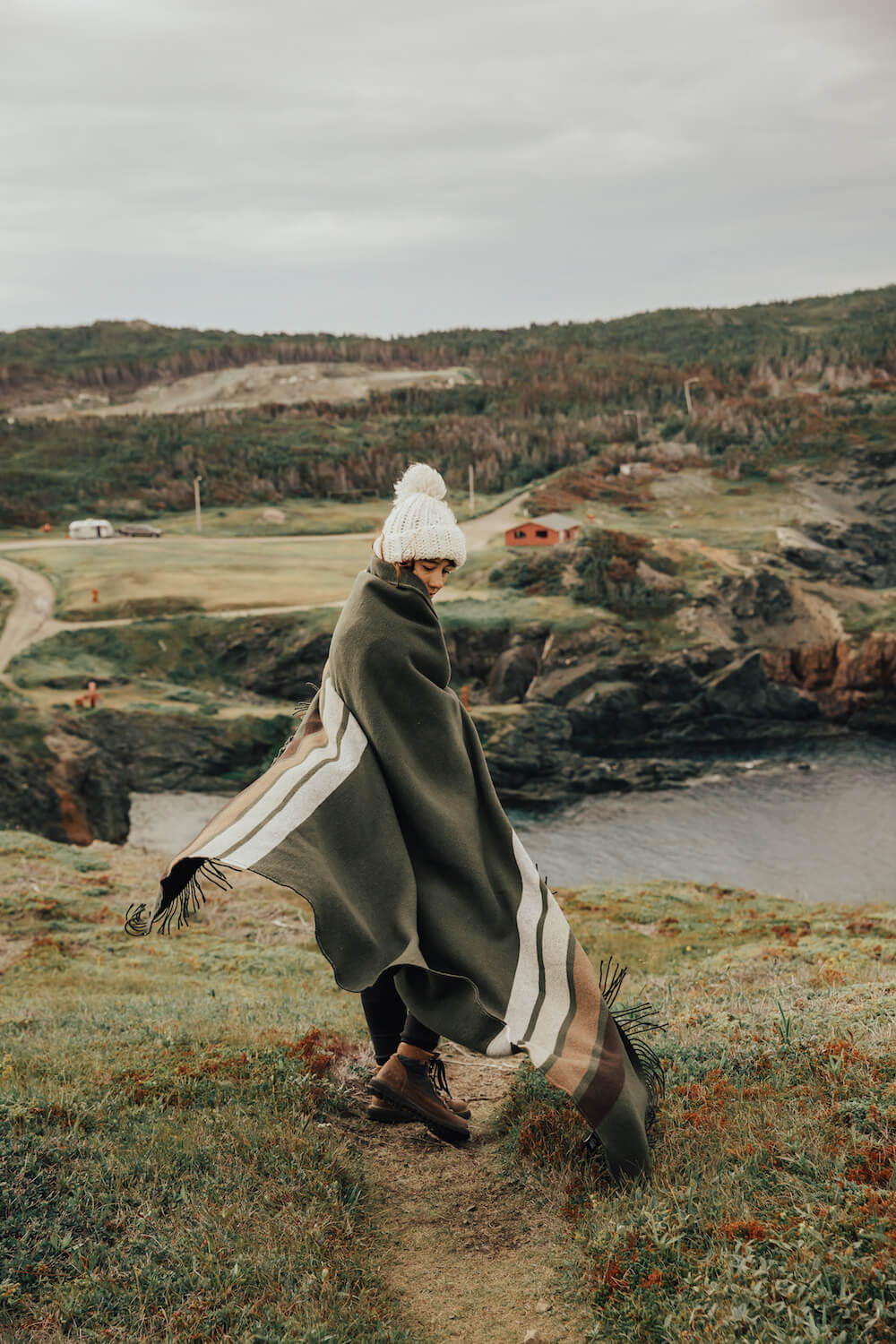 Person walking on a path by a scenic coastal landscape
