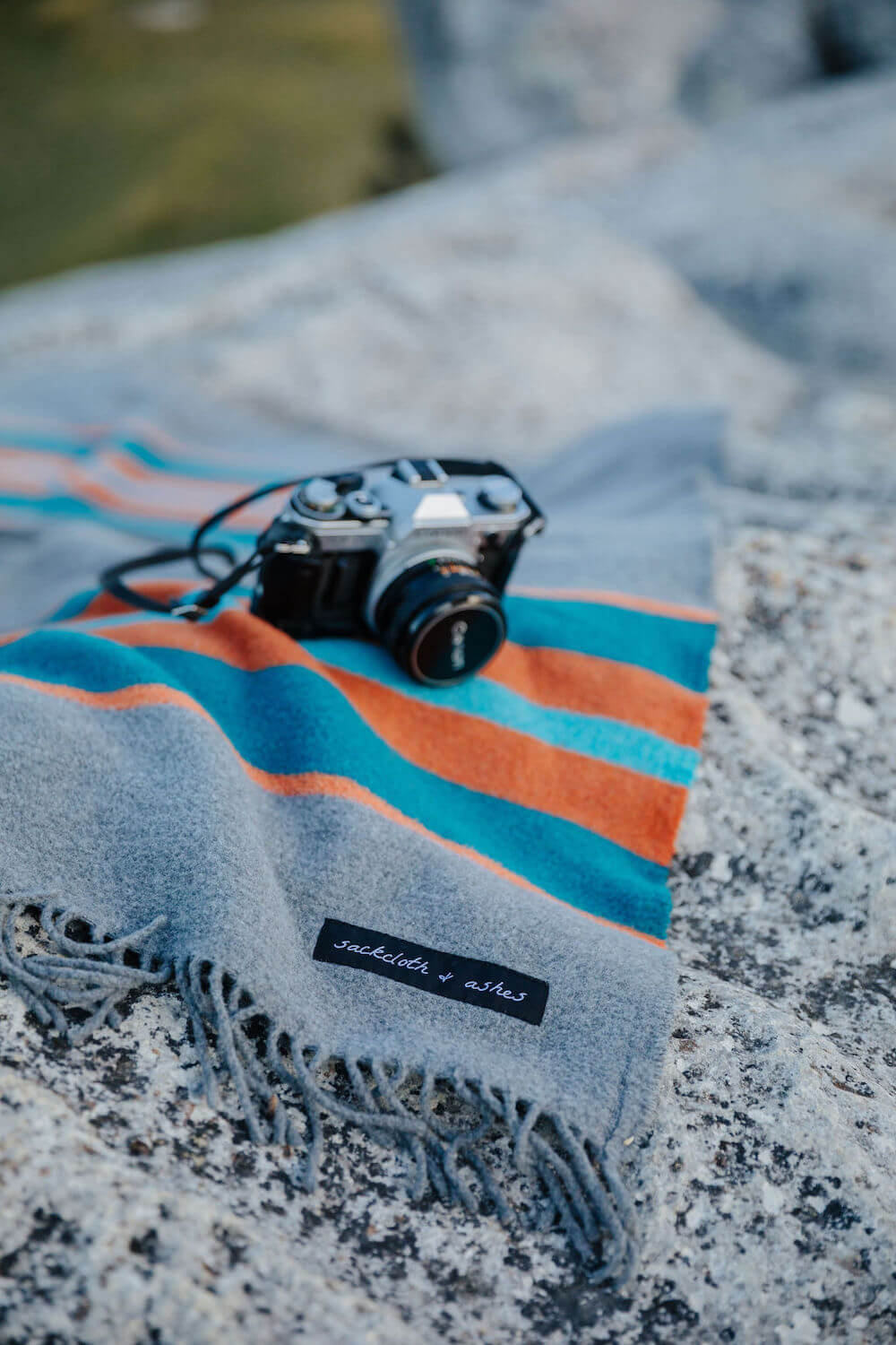 Camera on a striped fabric with a blurred natural background