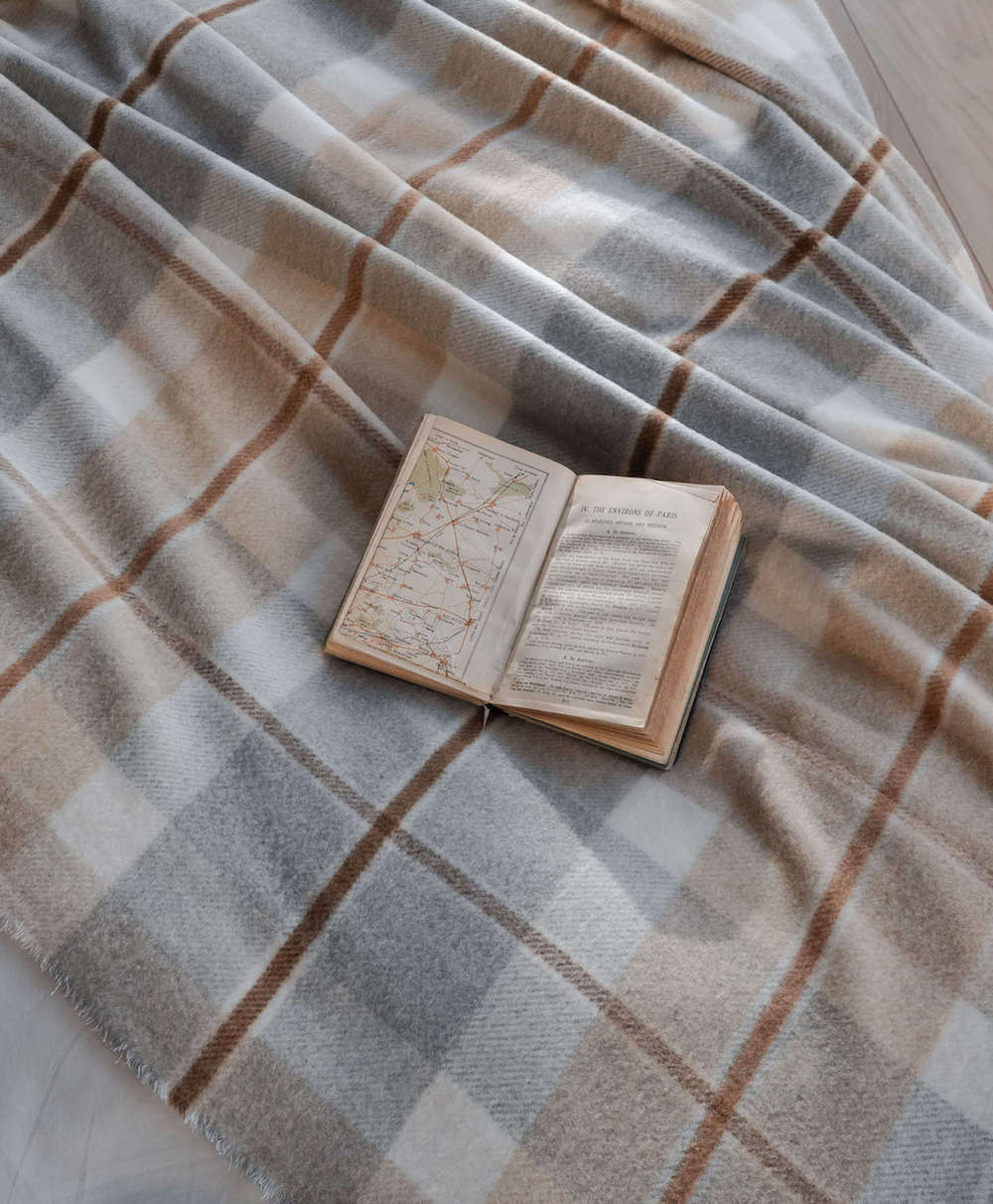 Open book on a plaid fabric surface