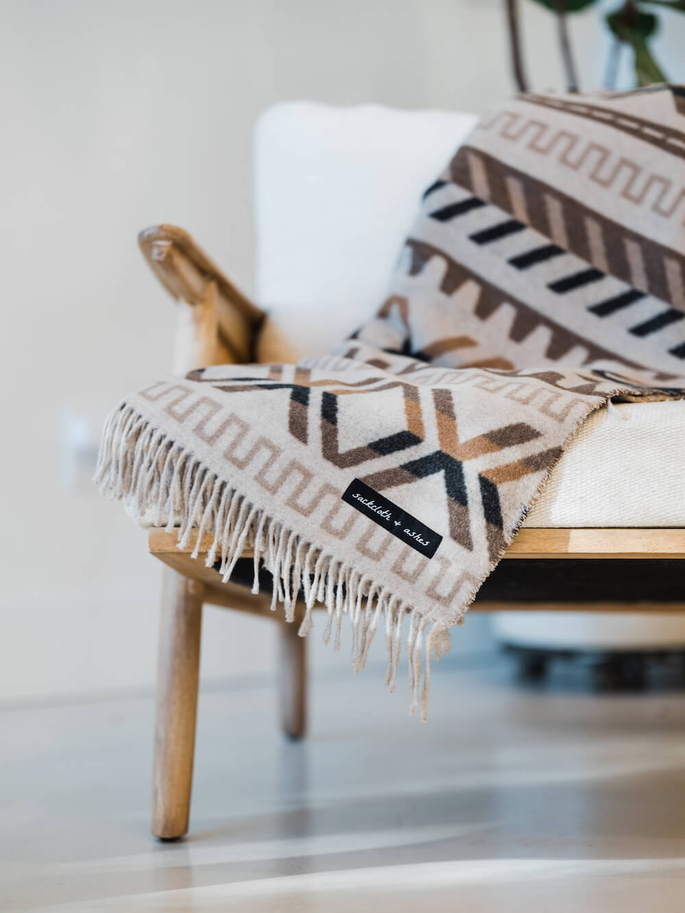 Patterned throw blanket draped over a chair with a blurred background